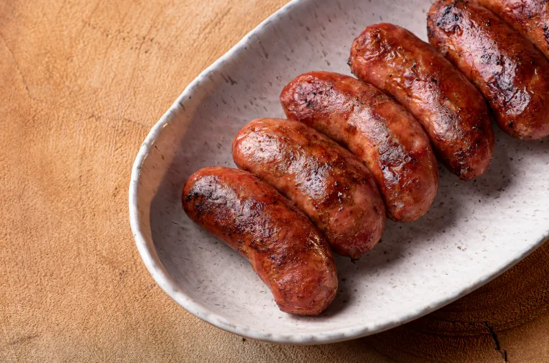 Grilled linguiça sausages on a ceramic plate